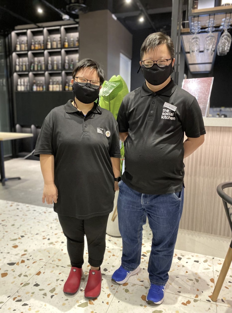 Two people wearing The Social Kitchen uniforms